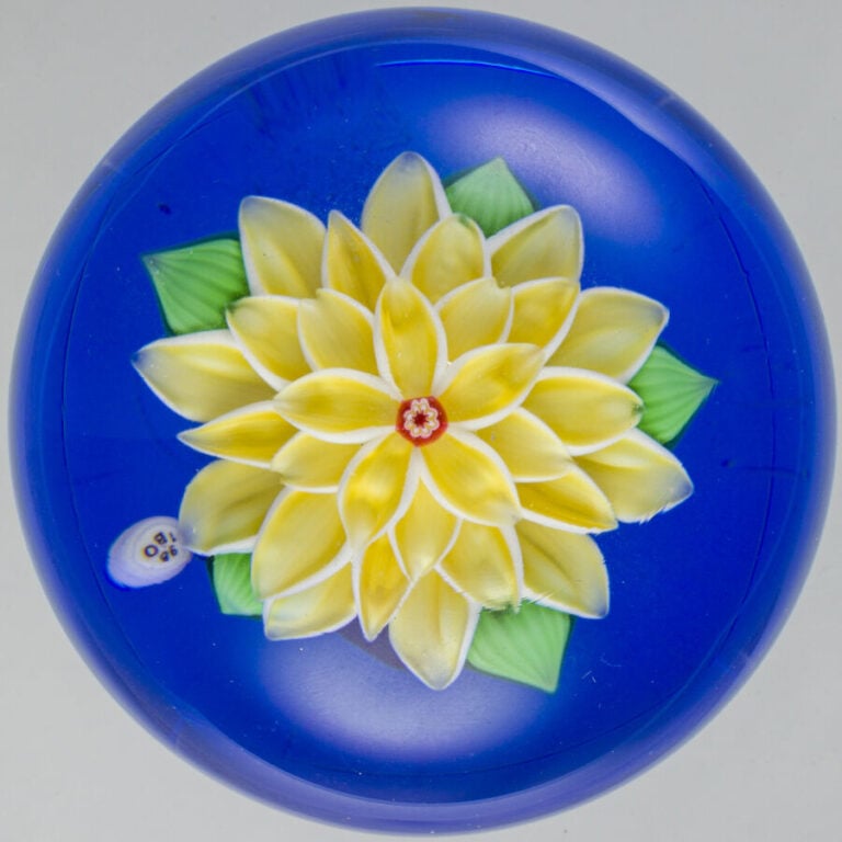 Baccarat. Presse-papiers signé et daté B 1980, à fond bleu translucide orné d'u…