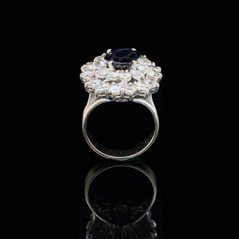 BAGUE « Pompadour » en or gris (750‰) ajouré, serti d'un saphir ovale foncé (ég…