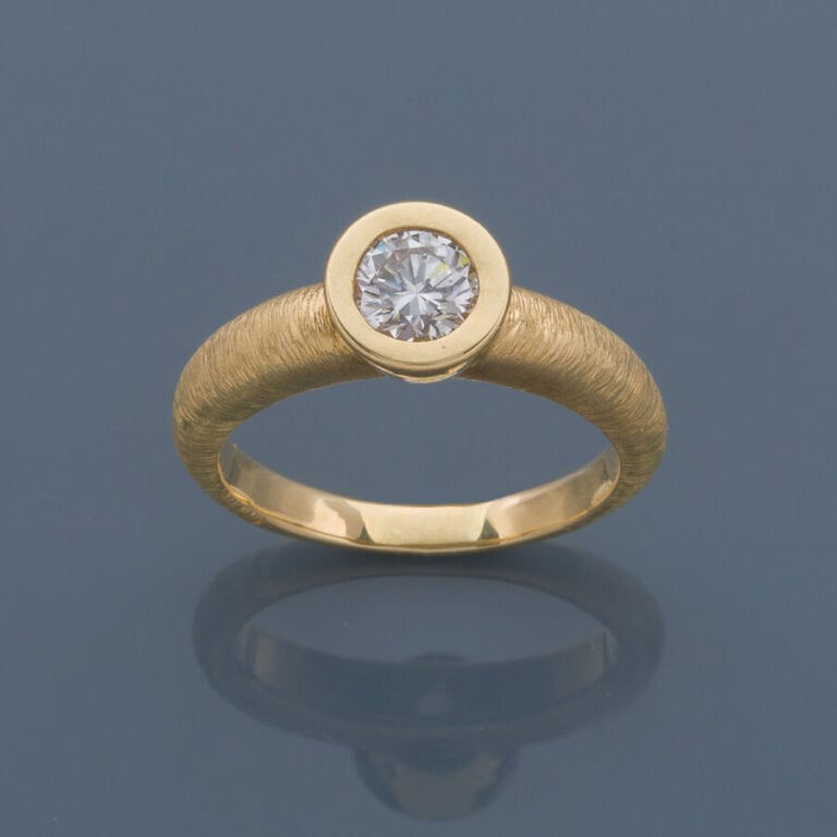BAGUE solitaire en or jaune (750‰) finement ciselé, serti d'un diamant taille b…