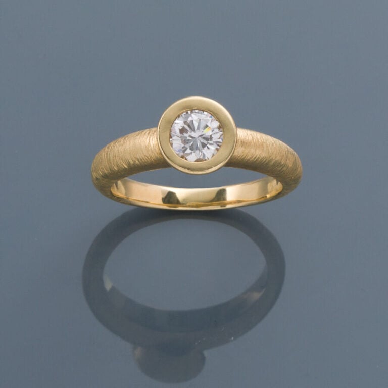BAGUE solitaire en or jaune (750‰) finement ciselé, serti d'un diamant taille b…