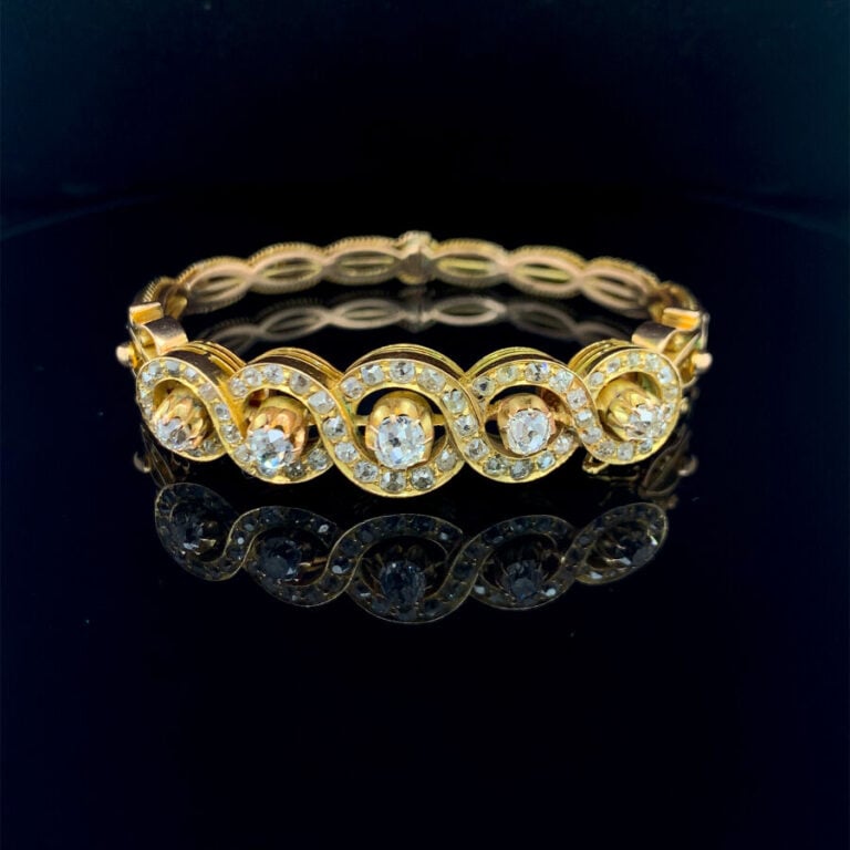 BRACELET rigide ouvrant en or jaune et or rose (585‰) 14 carats, ajouré et part…