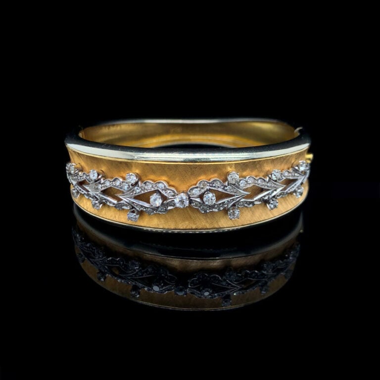 BRACELET rigide ouvrant légèrement incurvé en or jaune (750‰) et or gris (585‰)…