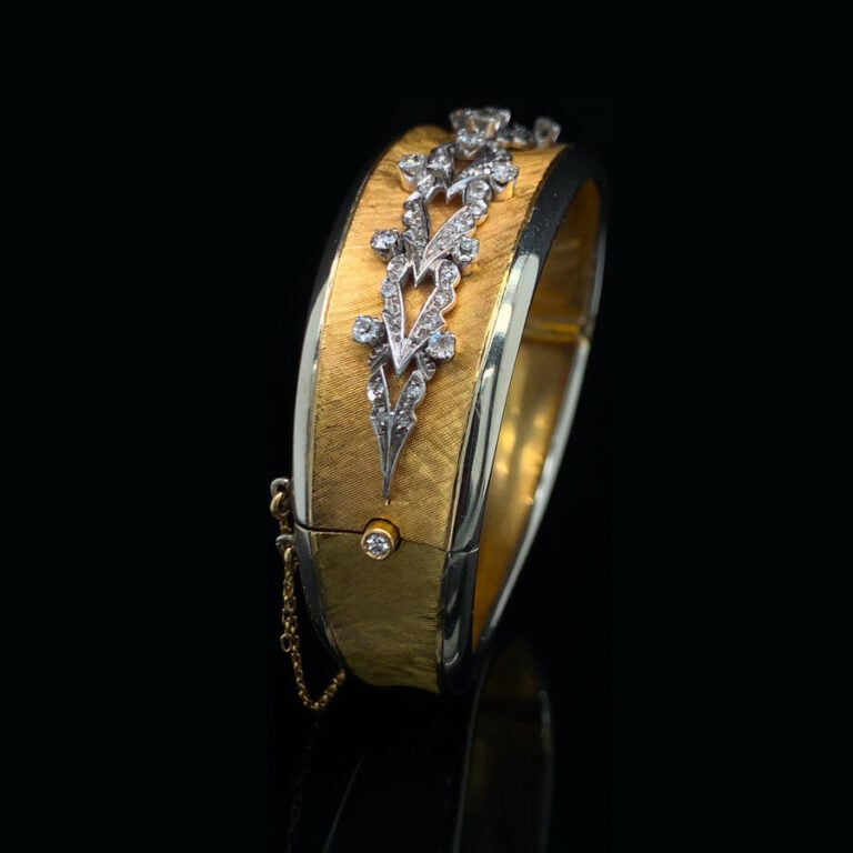 BRACELET rigide ouvrant légèrement incurvé en or jaune (750‰) et or gris (585‰)…