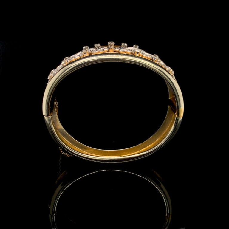 BRACELET rigide ouvrant légèrement incurvé en or jaune (750‰) et or gris (585‰)…