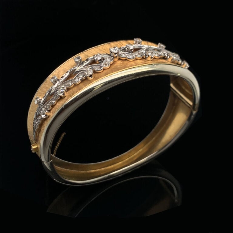 BRACELET rigide ouvrant légèrement incurvé en or jaune (750‰) et or gris (585‰)…