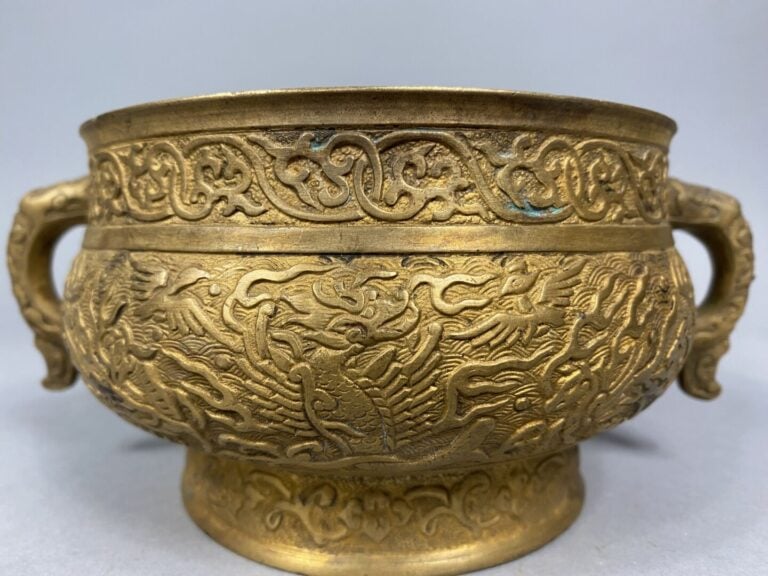Chine - Brûle parfum en bronze doré reposant sur un petit pied et flanqué de de…