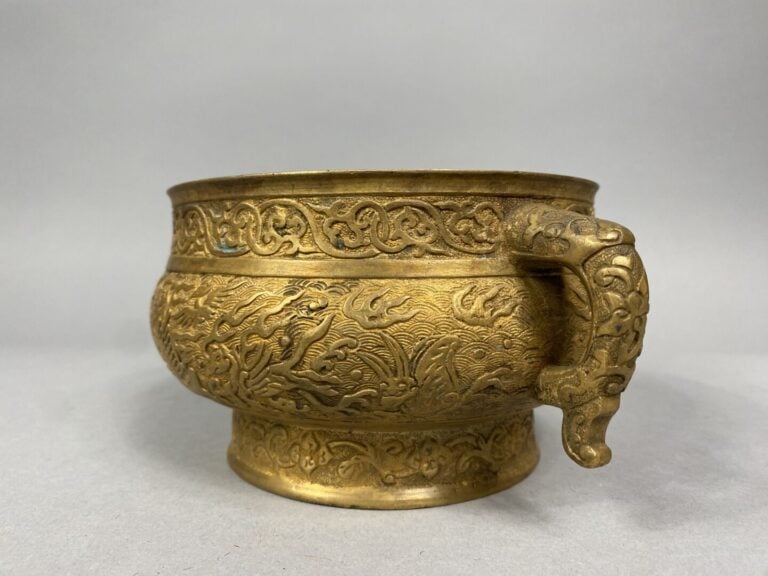 Chine - Brûle parfum en bronze doré reposant sur un petit pied et flanqué de de…