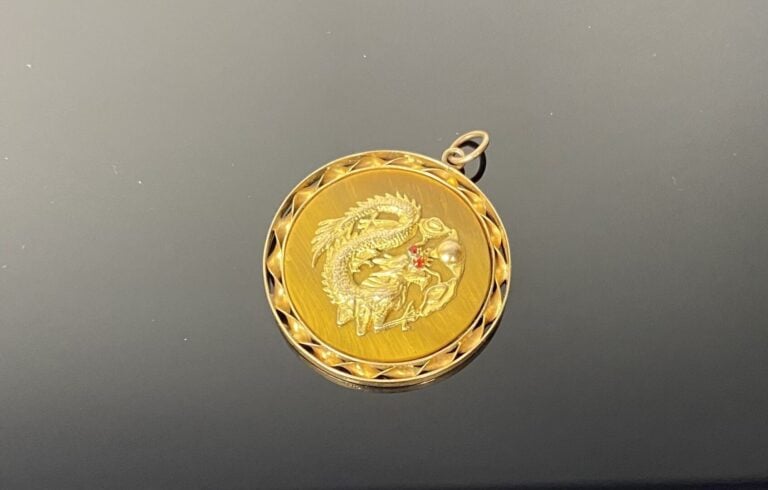 **Chine - Pendentif rond en oeil de tigre et entourage torsadé en or (9K). Le m…