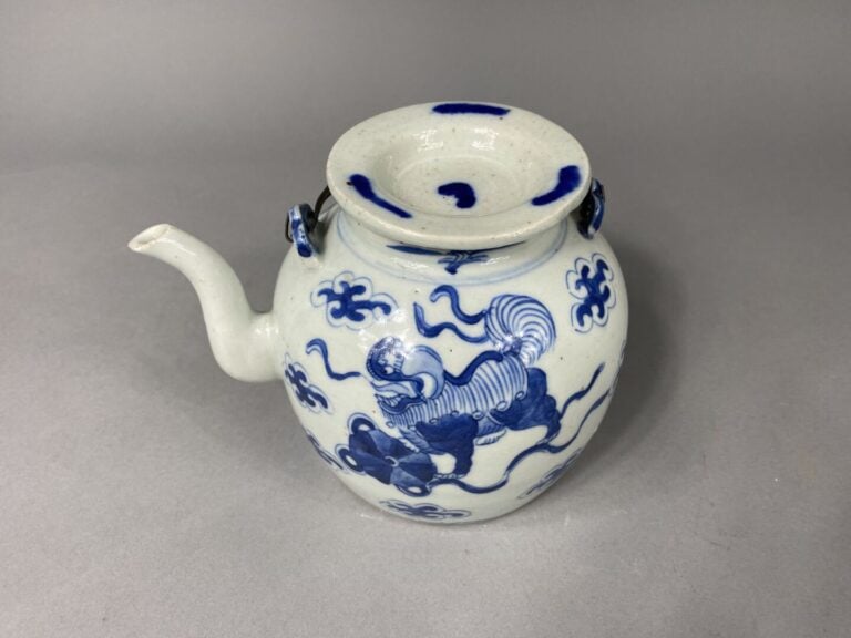Chine - Théière en porcelaine bleu blanc à décor de chiens de Fô dans des nuées…