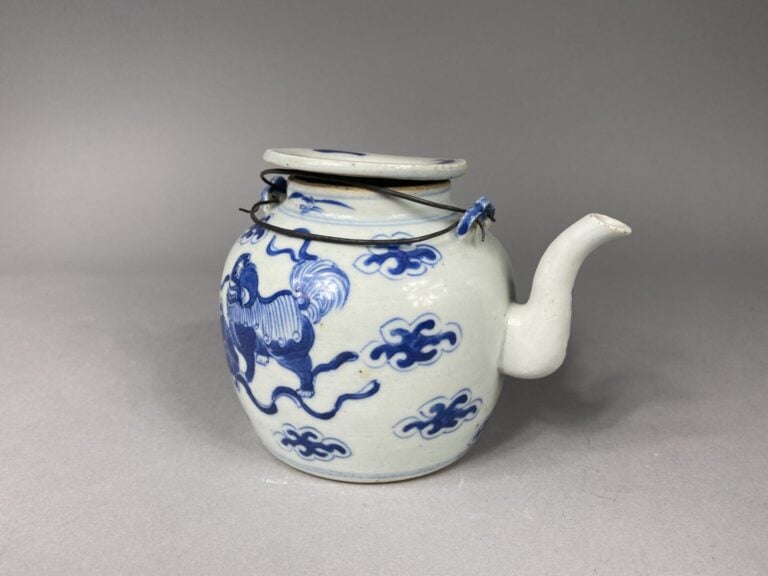 Chine - Théière en porcelaine bleu blanc à décor de chiens de Fô dans des nuées…
