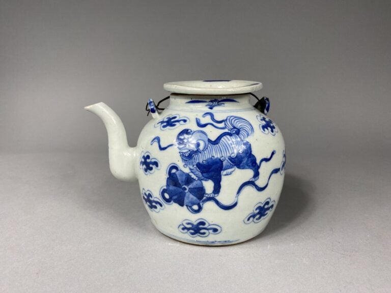 Chine - Théière en porcelaine bleu blanc à décor de chiens de Fô dans des nuées…