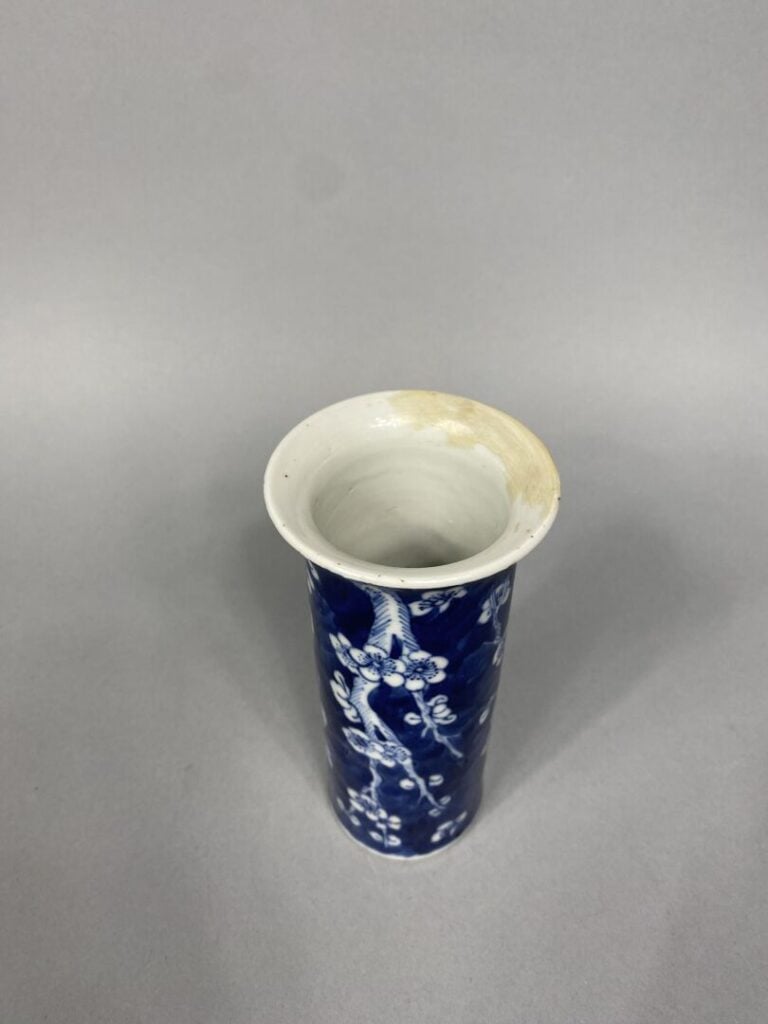 Chine - Vase cornet en porcelaine bleu blanc à décor de prunus sur fond bleu -…