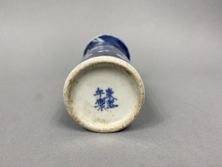 Chine - Vase cornet en porcelaine bleu blanc à décor de prunus sur fond bleu -…