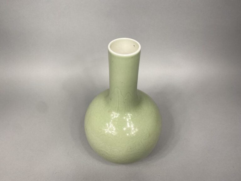 Chine - Vase de forme bouteille en porcelaine émaillé céladon à léger décor inc…
