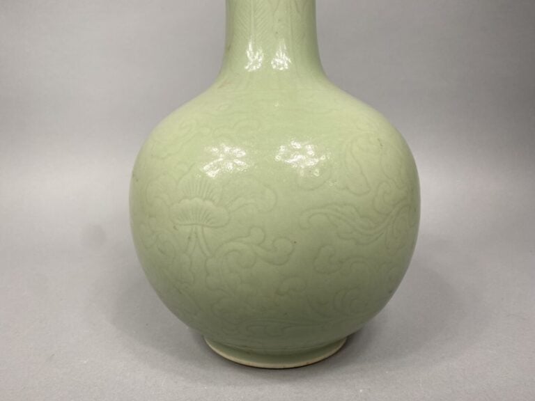 Chine - Vase de forme bouteille en porcelaine émaillé céladon à léger décor inc…