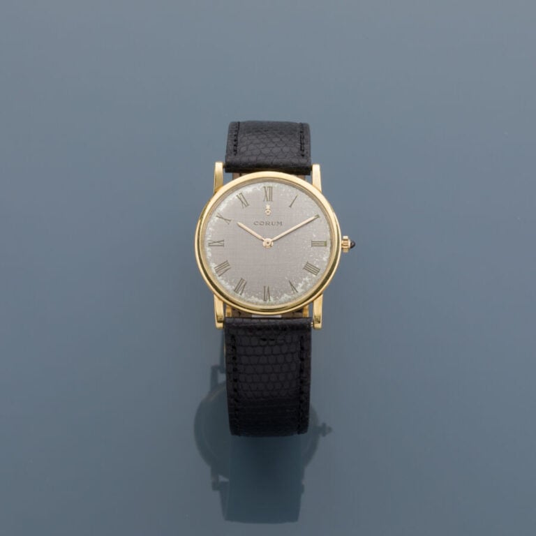 CORUM - BRACELET MONTRE ronde plate en or jaune (750‰). Cadran silver finement…