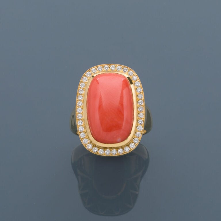 Importante BAGUE en or jaune (750‰) orné d'un corail cabochon de forme coussin…