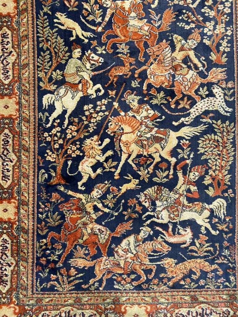 Iran - Tapis à décor de cavaliers sur fond bleu et frises de rinceaux et cartou…
