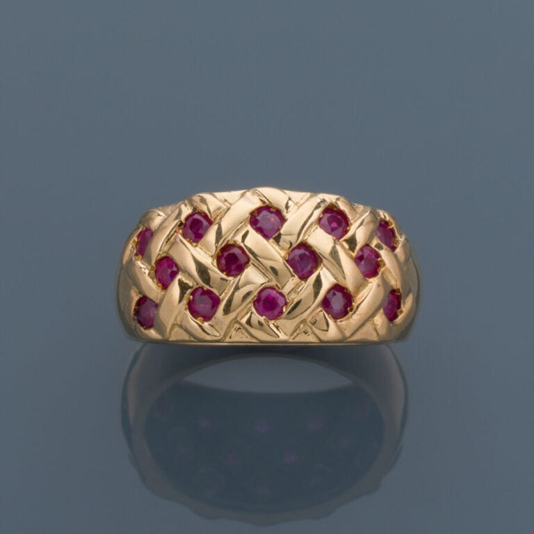 Large BAGUE bandeau « tressé » en or jaune (750‰) serti de rubis ronds. - Doigt…