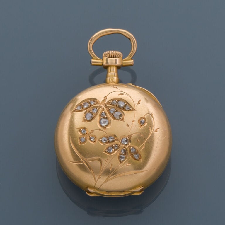 MONTRE de COL en or jaune (750‰) ciselé à décor de fleurs et serti de diamants…