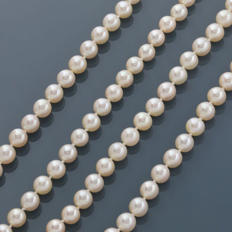 SAUTOIR composé d'un rang de perles de culture blanches. Fermoir circulaire en…