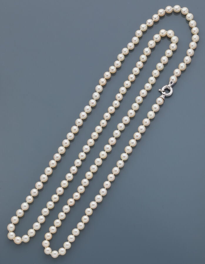 SAUTOIR composé d'un rang de perles de culture blanches. Fermoir circulaire en…