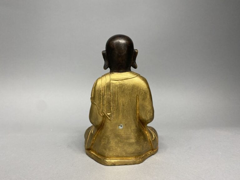 Tibet - Sculpture en bronze partiellement doré représentant un Luohan assis en…