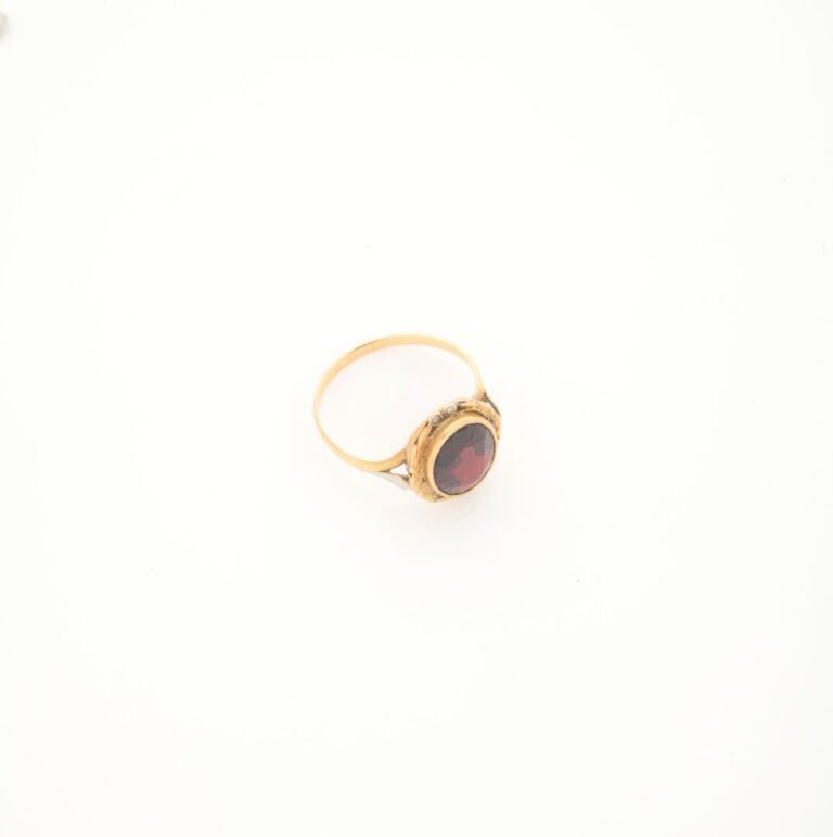 Bague en or jaune (750) ornée d'un grenat de taille ovale facetté en serti clos…