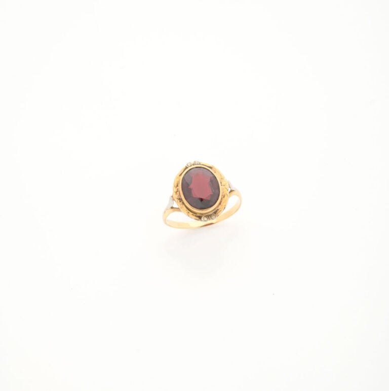 Bague en or jaune (750) ornée d'un grenat de taille ovale facetté en serti clos…