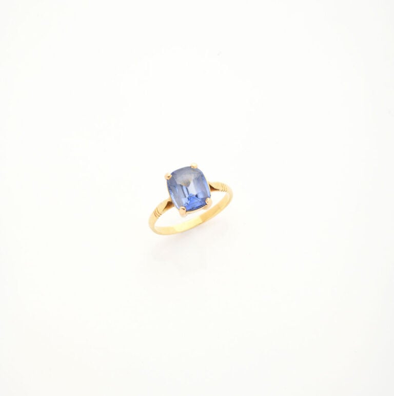 Bague en or jaune (750) ornée d'une pierre bleue facettée en serti clos - Poids…