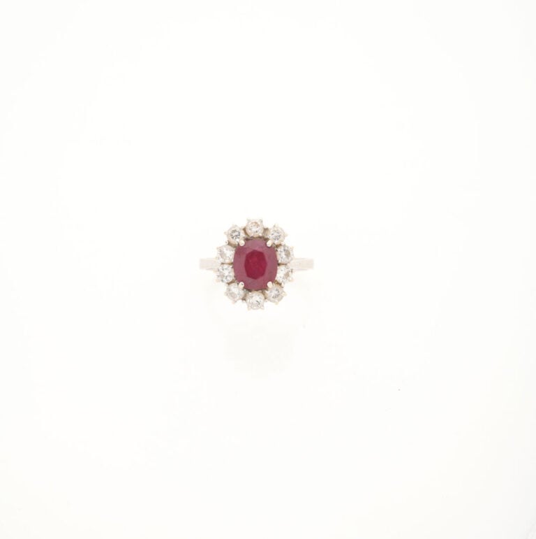Bague marguerite en or gris (750) ornée d'un rubis de taille ovale facettée dan…