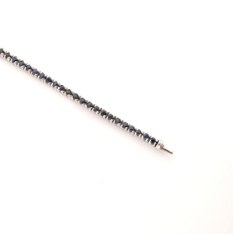 Bracelet ligne en or gris (750) serti de saphirs ronds facettés, fermoir clique…