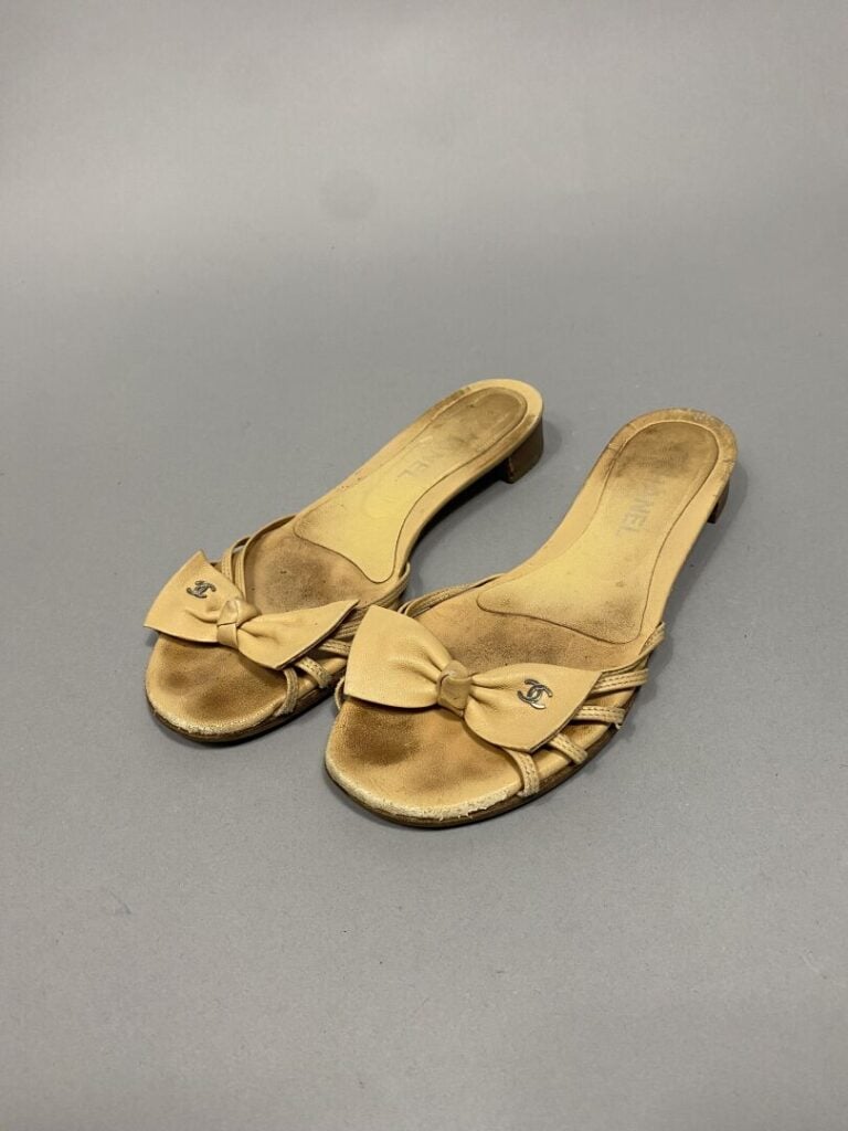 CHANEL - Paire de mules en cuir beige, lanières sur l'empeigne surmontées d'un…
