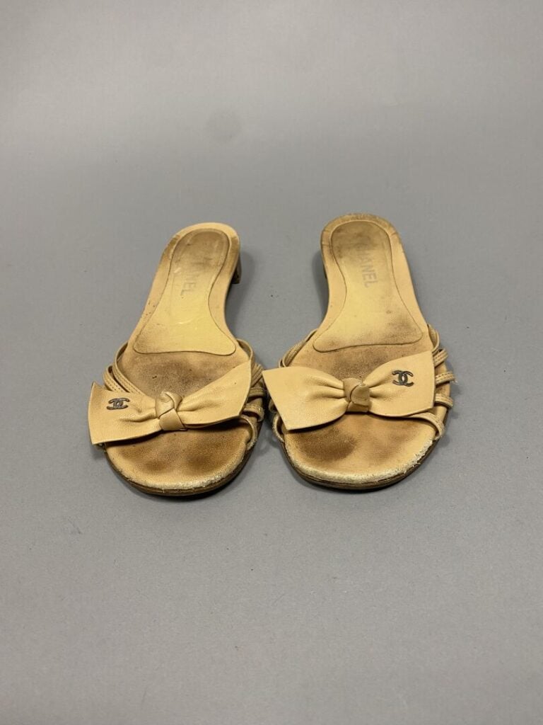CHANEL - Paire de mules en cuir beige, lanières sur l'empeigne surmontées d'un…