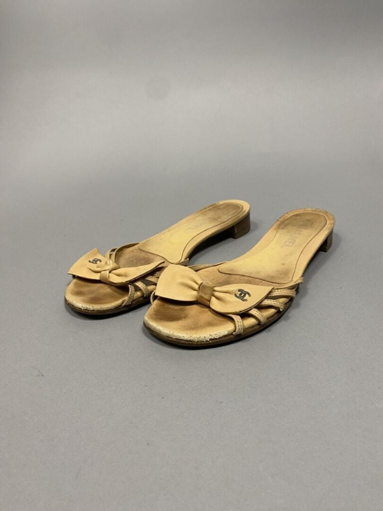 CHANEL - Paire de mules en cuir beige, lanières sur l'empeigne surmontées d'un…