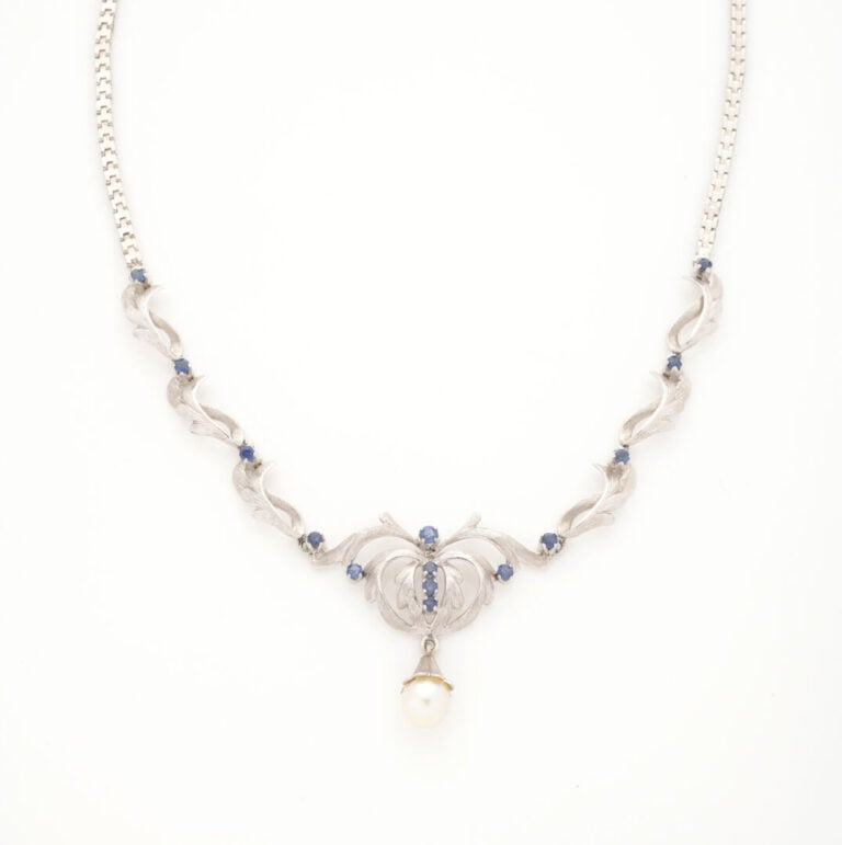 Collier en or gris (750) formé d'une maille articulée, le décolleté souligné d'…