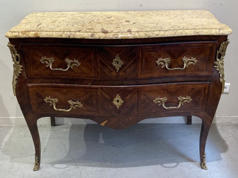 Commode de forme légèrement galbée en bois de placage ouvrant par deux tiroirs.…