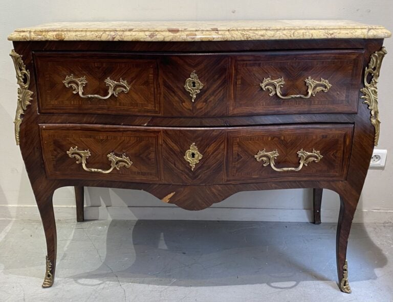 Commode de forme légèrement galbée en bois de placage ouvrant par deux tiroirs.…