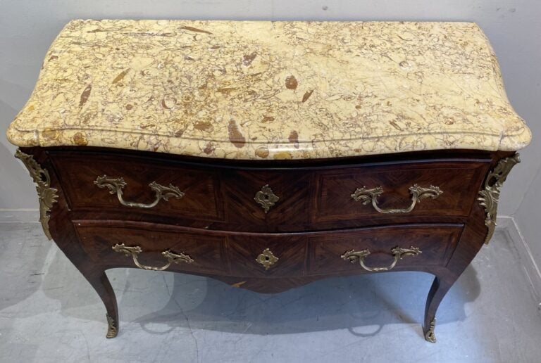 Commode de forme légèrement galbée en bois de placage ouvrant par deux tiroirs.…