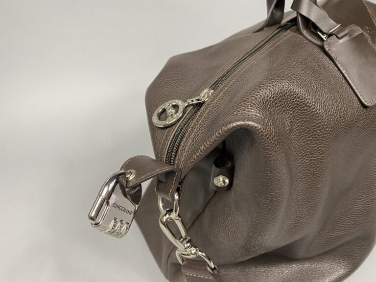 LONGCHAMP - Sac de voyage en cuir grainé dans les tons marron. Couture sellier…