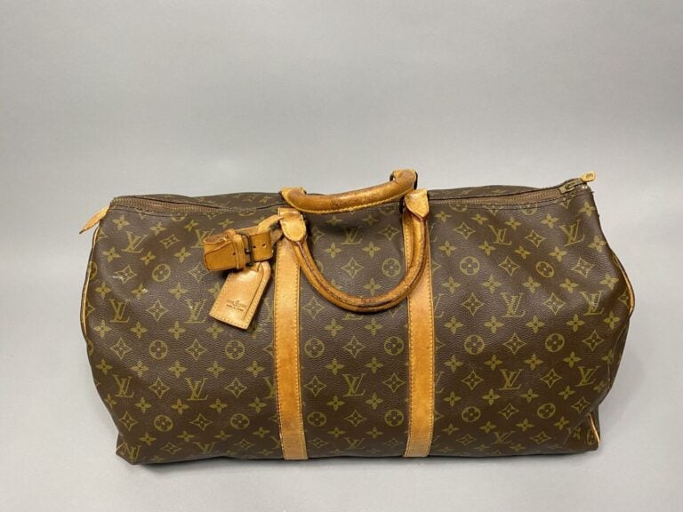 Louis VUITTON - Sac "Keepall 55" en toile monogram et cuir naturel. Double poig…
