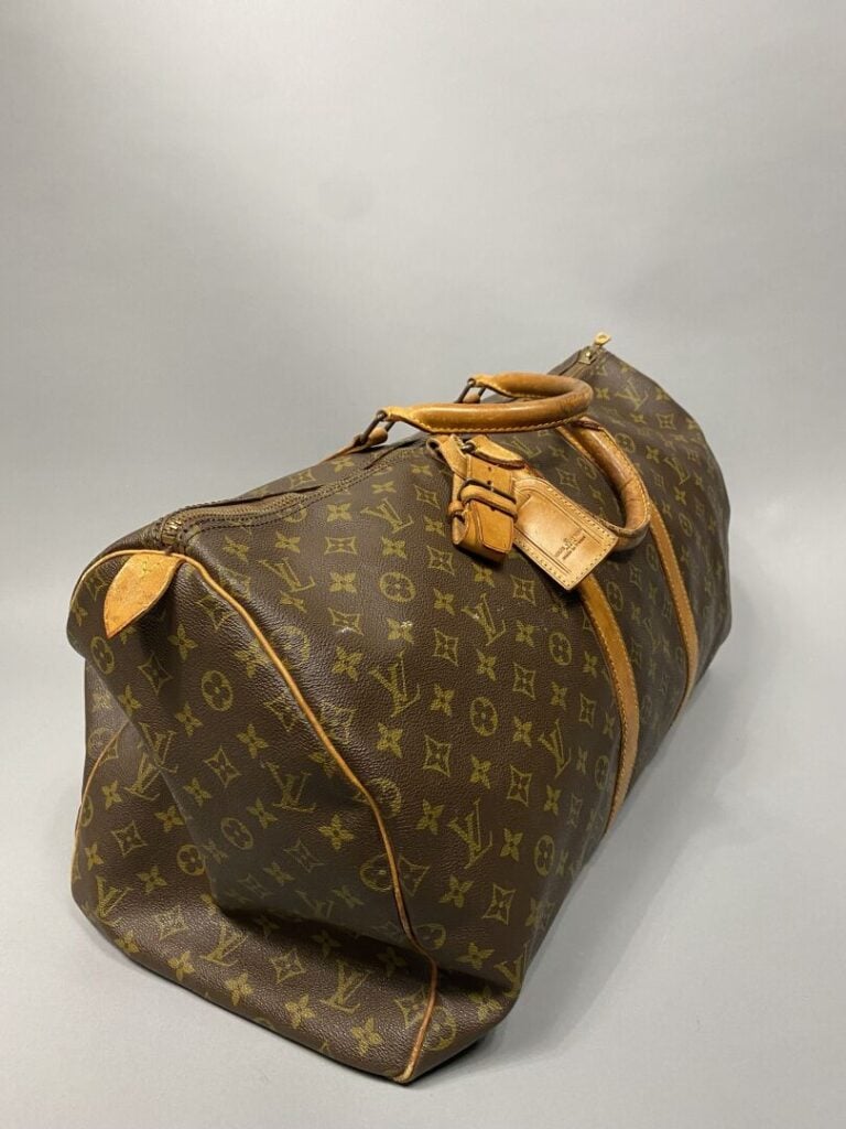 Louis VUITTON - Sac "Keepall 55" en toile monogram et cuir naturel. Double poig…