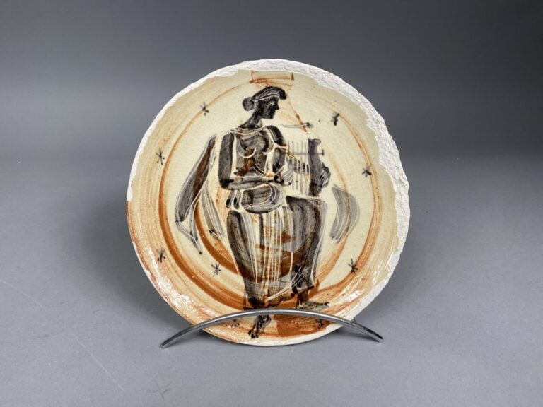 MADURA - Assiette en faience émaillée dans les tons bruns et noirs à décor d'un…