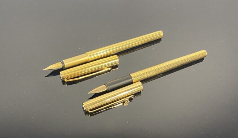 MONTBLANC - Ensemble de 2 stylos plume en métal doré à décor rainuré, l'un à pl…