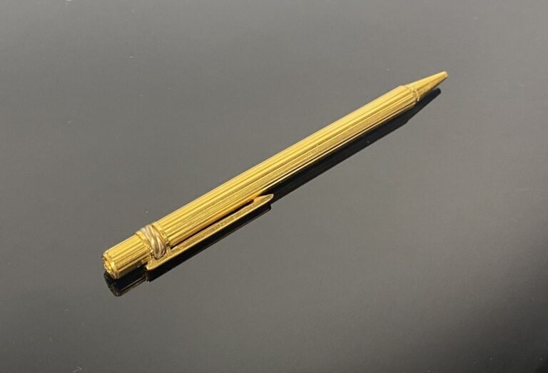 Must de CARTIER - Stylo à bille rétractable Trinity en métal doré à décor rainu…