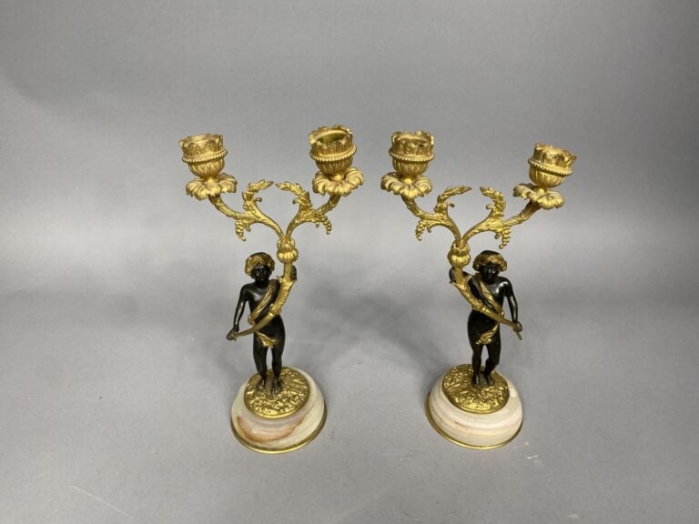 Paire de candélabres en bronze doré représentant deux chérubins couronnés de la…