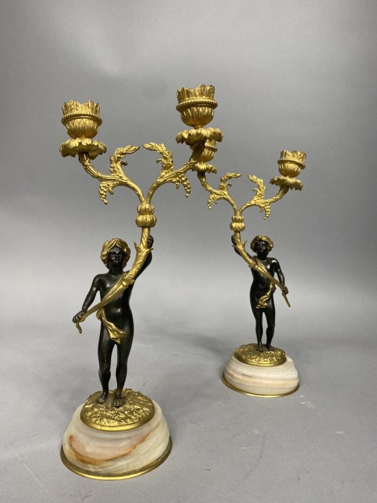 Paire de candélabres en bronze doré représentant deux chérubins couronnés de la…