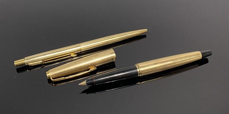 PARKER - Lot comprenant un stylo plume en métal doré finement rainuré, et un st…