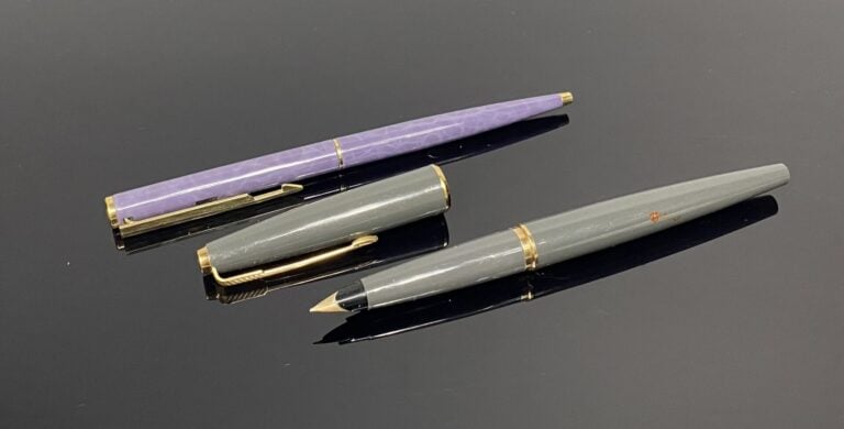 PARKER - Lot comprenant un stylo plume en résine grise, attributs en métal doré…