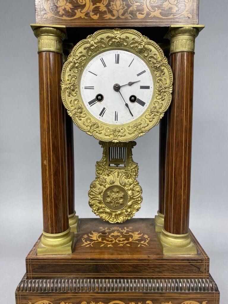 Pendule portique en palissandre à décor marqueté de bois clair à décor de rince…